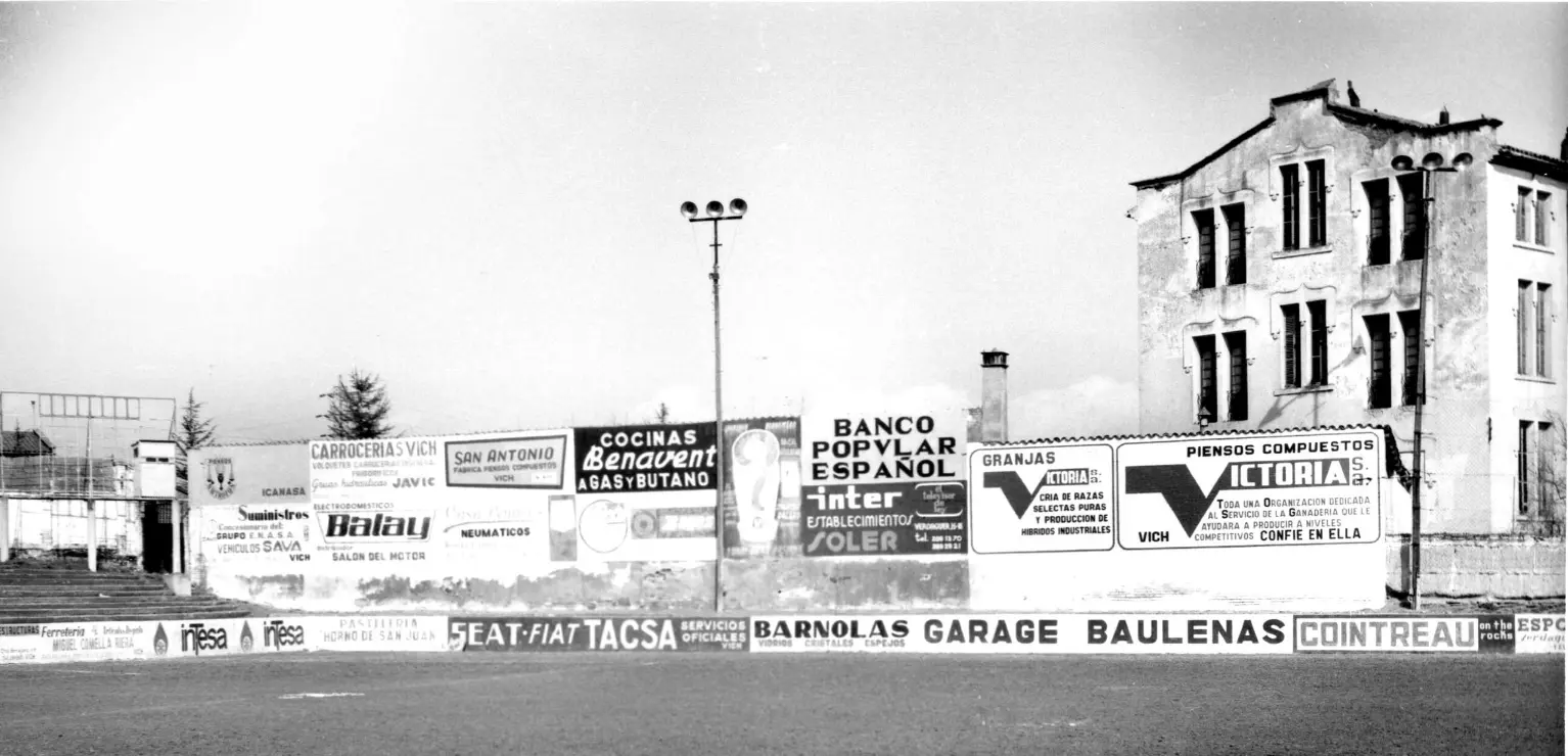 Paret d’estadi plena d’anuncis antics, origen de MC Urban.